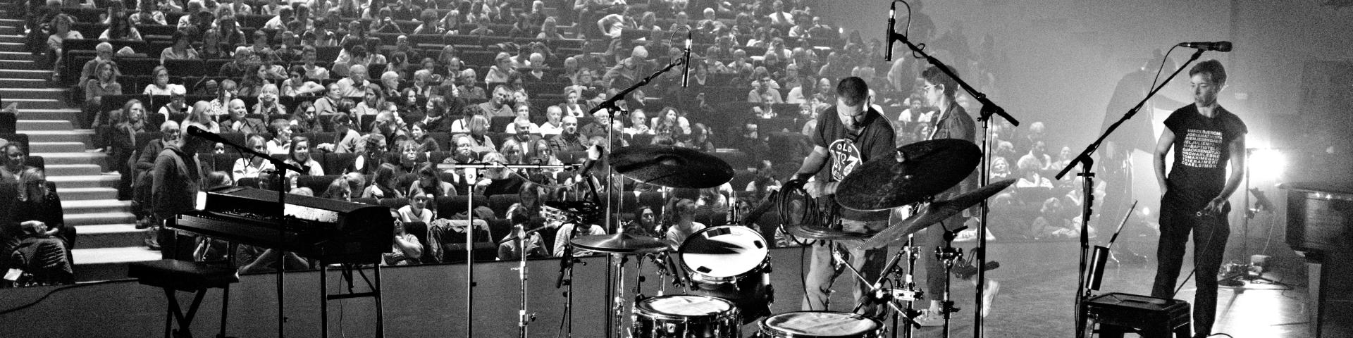 Concert : spectateurs devant la scène avec groupe - Photo en noir et blanc