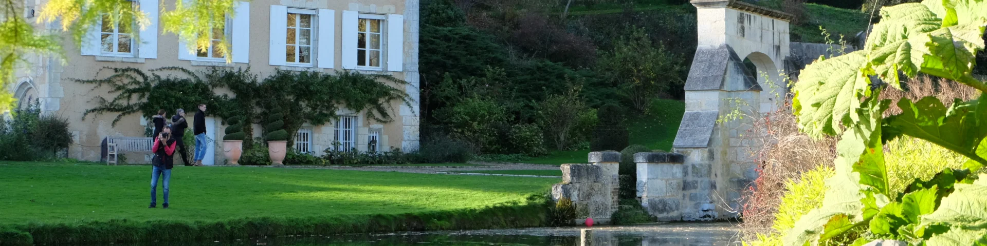Jardin avec vue sur maison de caractère et point d'eau