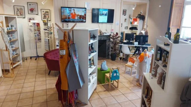 Vue d'ensemble d'une pièce avec meubles et produits à vendre, au fond deux télévisions accrochées au mur