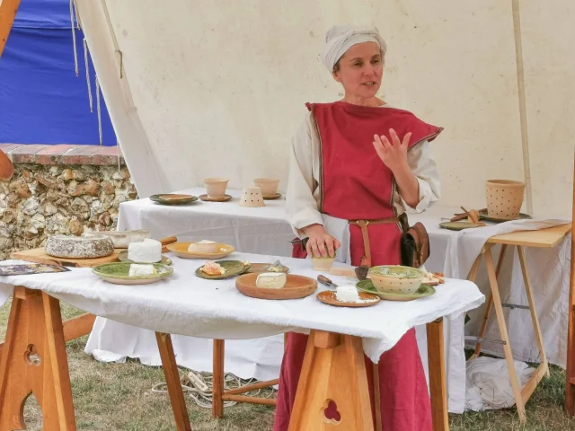 Dégustation de fromage avec une personne costumée derrière une table sur laquelle il y a des fromages