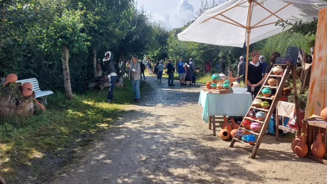 Vue sur des visiteurs dans chemin avec poterie sur un stand à droite