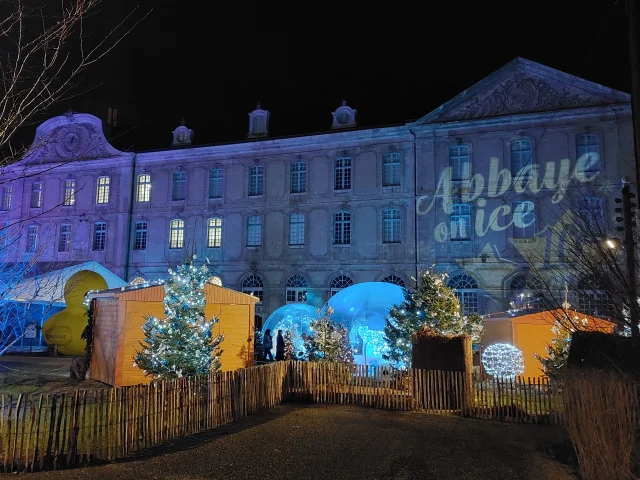 Grand bâtiment de nuit avec devant patinoire, boule de Noël XXL