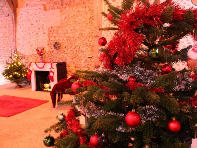 Zoom sur un sapin de Noël avec en fond une cheminée
