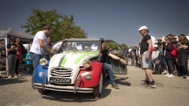 Personnes autour d'une 2CV bleu blanc rouge
