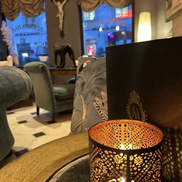 En premier plan lumière avec au fond salon table et fauteuils gris