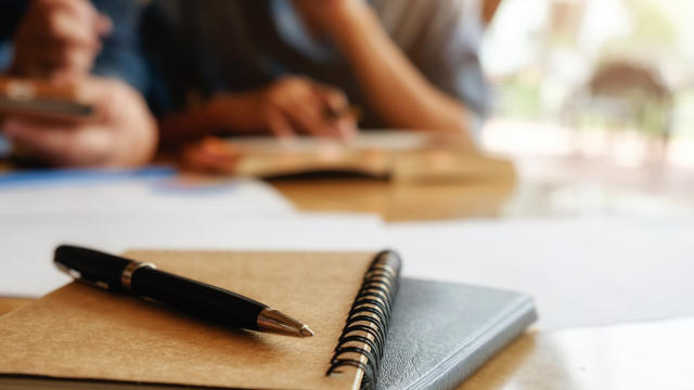 Education concept. Student studying and brainstorming campus concept. Close up of students discussing their subject on books or textbooks. Selective focus.