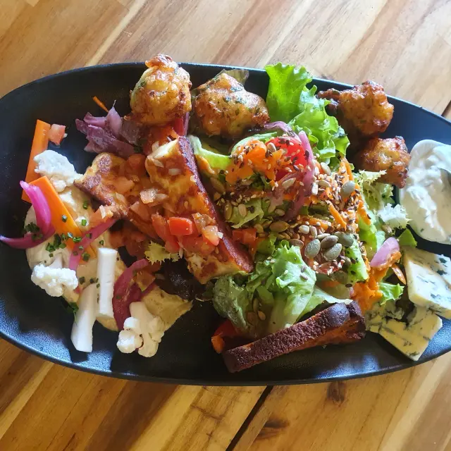 Salade avec des morceaux de poulet croustillants, des légumes frais et une sauce blanche