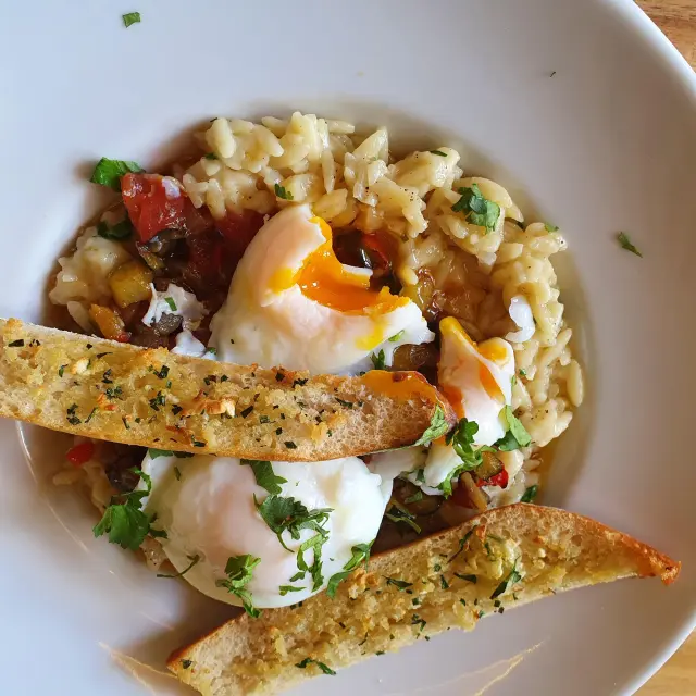 Assiette avec des pâtes, un œuf poché et des croûtons