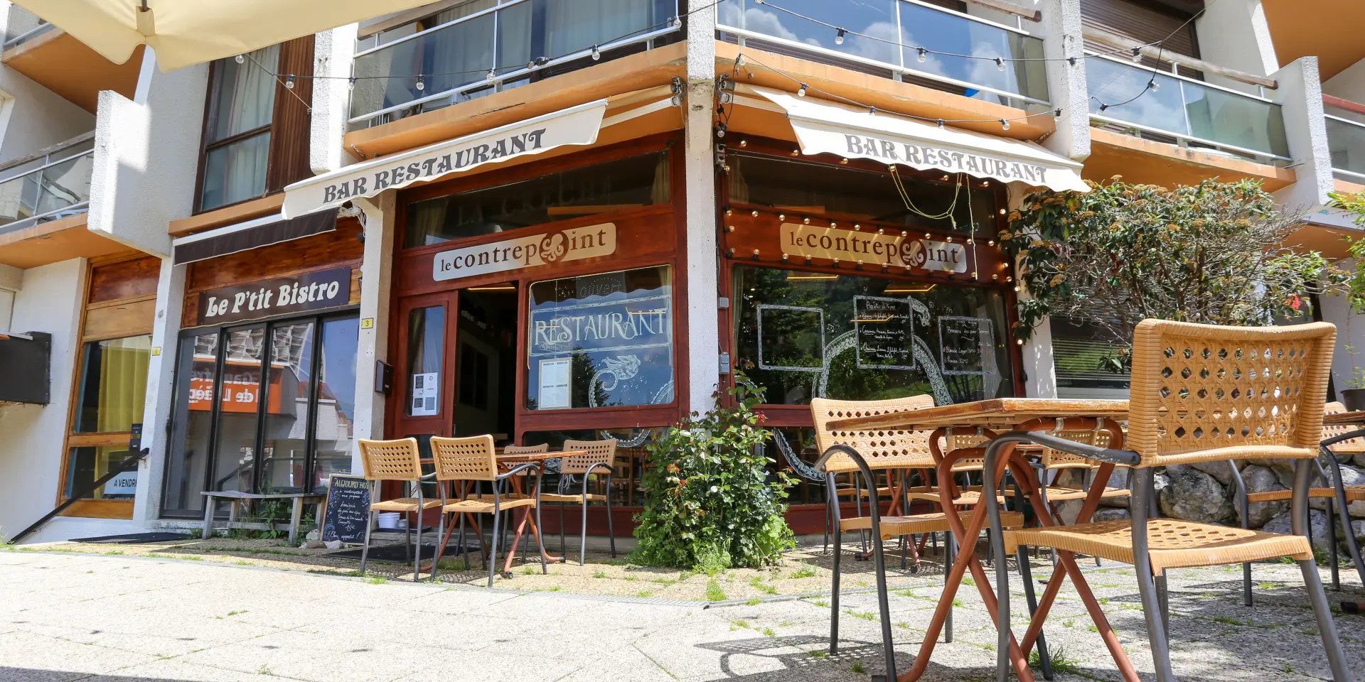 Restaurant avec terrasse ensoleillée et chaises en osier