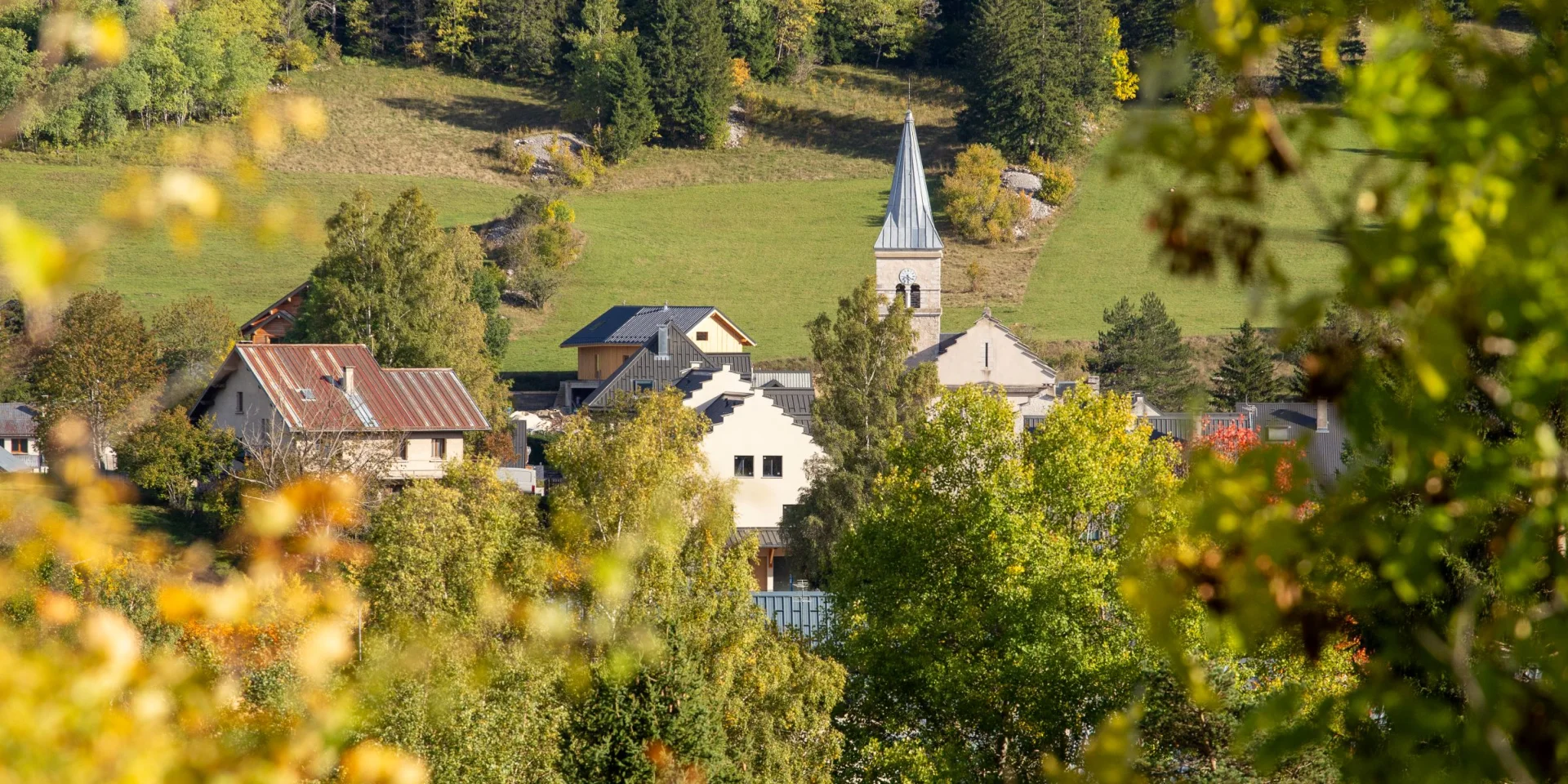 Village avec une église et des maisons entourées de verdure