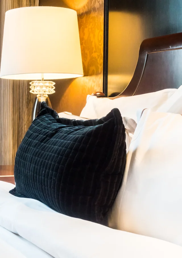 White pillow on bed with table light lamp decoration in bedroom interior