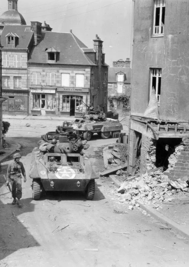 photo en noir et blanc d'une ville normande au moment de la libération par les alliés.