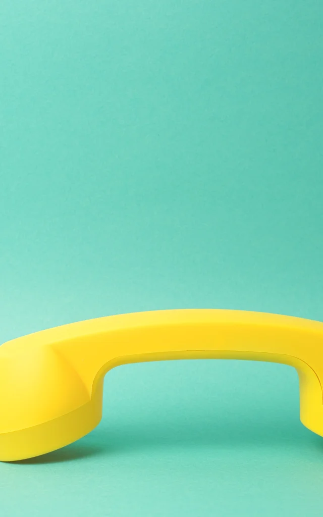 Combiné de téléphone jaune sur fond turquoise