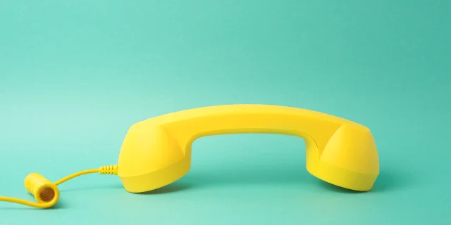 Yellow Telephone Receiver Turquoise Background