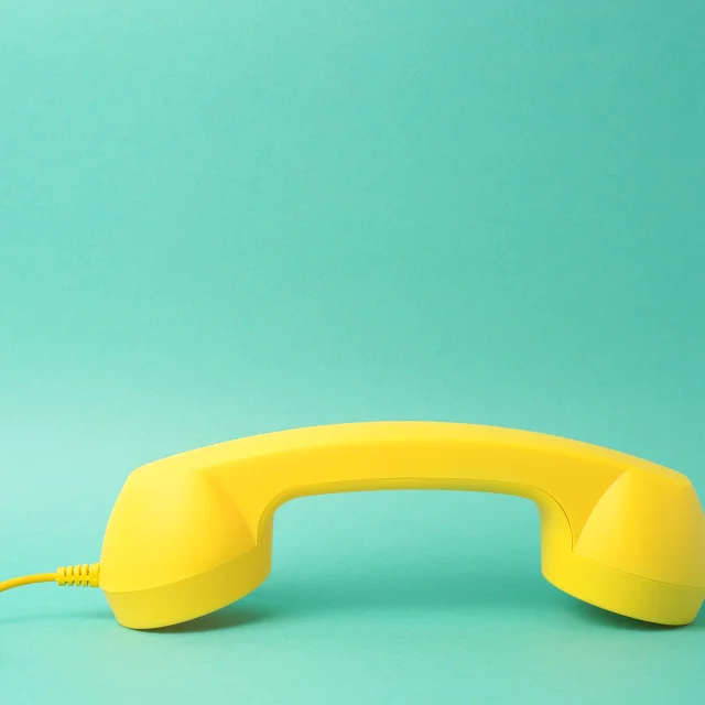 Yellow Telephone Receiver Turquoise Background