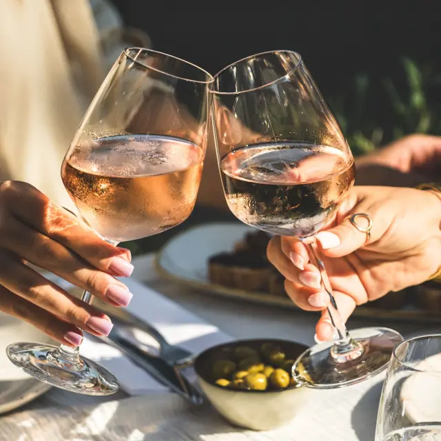 Deux verres de vin rosé de Provence qui s'entrechoquent lors d'un moment convivial en terrasse à Roquebrune-sur-Argens, dans le Var.